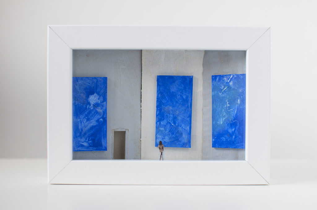 Dono d'arte per la Biennale di Venezia una donna osserva tre quadri blu monocromi